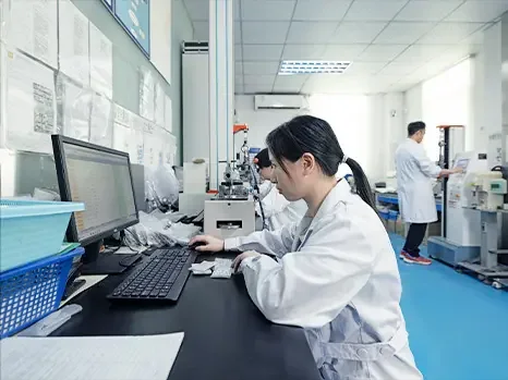 Membro da equipe em uma bancada de laboratório com um microscópio e um computador